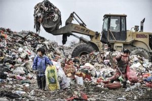 niños chinos recogiendo basura en un tiradero